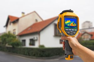 handheld thermal camera pointed at a house